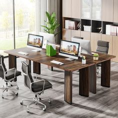 an office desk with two monitors on it and some chairs in front of the desk