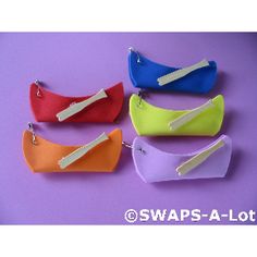 four zippered pouchs are lined up on a purple surface