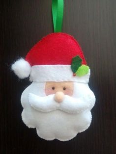 a santa clause ornament hanging on a door with a green ribbon around it