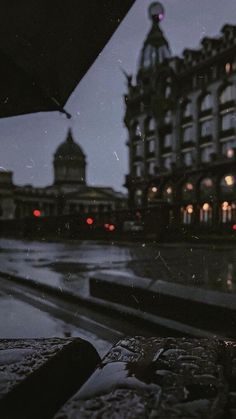 a rainy night in the city with buildings and street lights