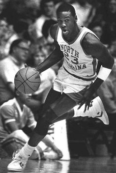 an old photo of a basketball player dribbling the ball while people watch from the sidelines