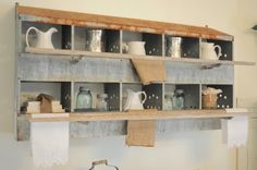 an old wooden shelf filled with lots of jars and other items on top of it