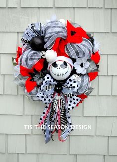 a red and black wreath hanging on the side of a brick wall