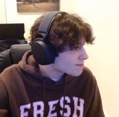 a young man wearing headphones while sitting on a couch