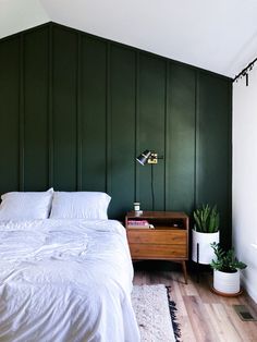 a bedroom with green walls and white bedding