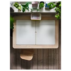 an overhead view of a wooden table with two doors and some plants on the wall