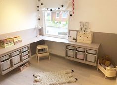 a child's playroom with toys and storage bins on the floor in front of a window