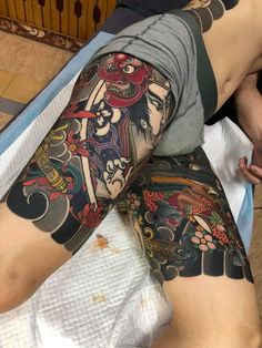 a person laying on a bed with tattoos on their legs