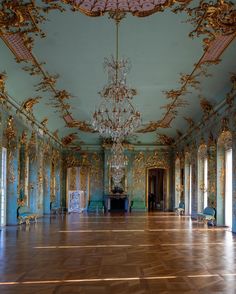 an ornately decorated room with chandeliers and mirrors on the walls, along with wooden flooring