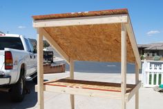 a truck is parked in front of a house with a wooden structure attached to it