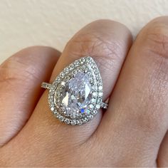 a woman's hand with a diamond ring on top of her finger and an engagement band