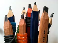 several pencils are lined up next to each other with erasers in them on a table