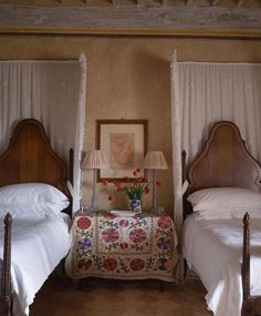 two beds in a bedroom with white linens