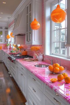 a kitchen with white cabinets and pink countertops, oranges are on the counters