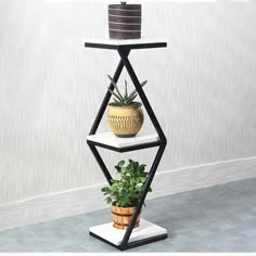 a three tiered shelf with a potted plant on top and a vase in the middle