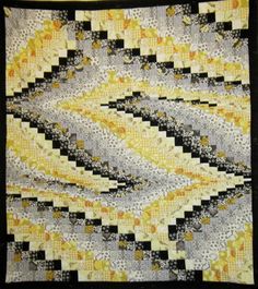 a yellow and black quilt is on display