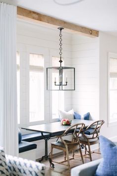 a dining room table with blue chairs and white walls