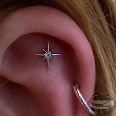 an ear piercing with a star design on it