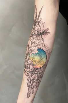 a person with a tattoo on their arm that has flowers in the center and a bird flying over it