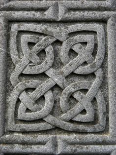 an intricate design on the side of a stone wall with knots and interlaces