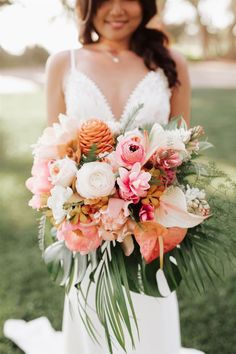 a woman holding a bouquet of flowers in her hands