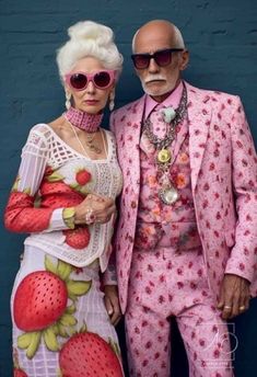 an older man and woman in matching outfits