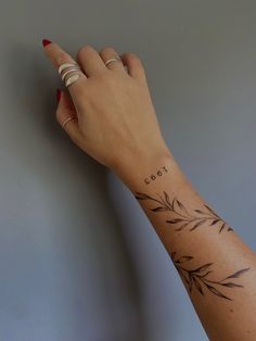 a woman's hand with a small tattoo on her left wrist and the word cool written in cursive writing