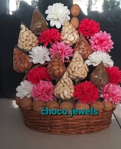 a basket filled with lots of different types of nuts and flowers on top of a table