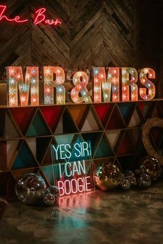 a neon sign that says mr and mrs in front of some shiny balls on the floor