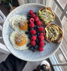 an egg, toast and berries on a plate