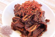 a white plate topped with sliced beef and sprouts