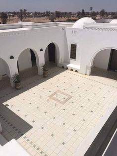 an empty courtyard with tiled floors and white walls