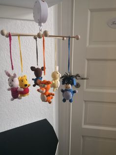 several stuffed animals hanging from a hook in a room