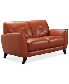 a brown leather couch sitting on top of a white floor