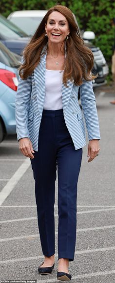 the woman is walking down the street in her blue suit