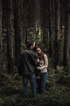 a man and woman standing in the woods