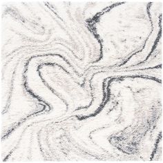 a white rug with black and grey swirls on it's edges, in the shape of a heart