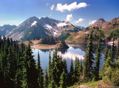 a lake surrounded by pine trees and mountains