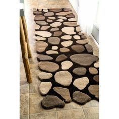 a brown and white area rug on the floor next to a door with a wooden handle