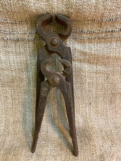 an old pair of scissors is hanging on the side of a piece of burlock