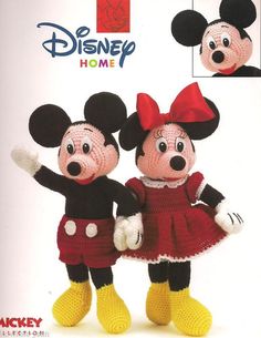 two crocheted mickey and minnie mouse dolls standing next to each other in front of a disney home advertisement