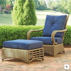 a wicker chair and ottoman with blue cushions