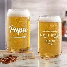 two beer glasses sitting on top of a counter