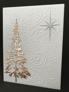 a white card with gold foil and a christmas tree