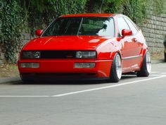 a red car is parked on the street