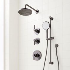 a shower head with thermostaer and hand held shower faucet in front of it