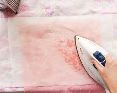 a person ironing fabric with an electric iron