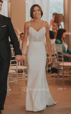 a bride and groom hold hands as they walk down the aisle at their wedding reception