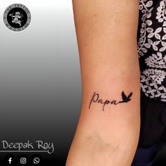 a woman's arm with the word papa written on it and a bird tattoo