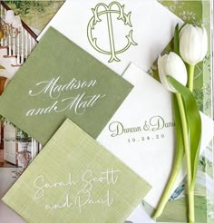 the wedding stationery is laid out on top of each other, with flowers in front of them